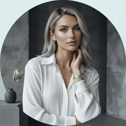 Portrait of influencer Amelia Gray wearing a loose-fit white pleated long-sleeved shirt against a minimalist studio backdrop.