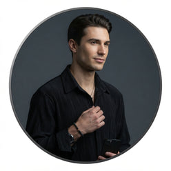 Marcus Thorne wearing a white pleated long-sleeved dress shirt in a professional circular portrait against a gray background.